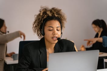 Agente de contact center com auscultadores a atender uma chamada ao computador, ilustrando a integração da Aircall com o HubSpot CRM